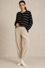 Striped Sugar Sweater in black – Ριγέ Πλεκτή Μπλούζα με Κουμπιά Κωδ:211026 Χαρακτηριστικά Προϊόντος Σύνθεση: Viscose – Modal Mix Ύφασμα: Λεπτό, εξαιρετικά απαλό πλεκτό viscose - modal blend Υφή: Λεία, φίνα και ιδιαίτερα ευχάριστη στην επαφή με το σώμα Γραμμή: Ελαφρώς oversized – relaxed fit Μέγεθος: One Size καλύπτει έως large Στρογγυλή λαιμόκοψη Μπροστινή πατιλέτα με μικρά κουμπιά Ribbed μανσέτες και τελείωμα Λεπτές οριζόντιες ρίγες Ανάλαφρη πλέξη χωρίς περιττό όγκο Ιδανικό για layering και καθημερινές εμφανίσεις Οδηγίες Φροντίδας 30°C – Πλύσιμο σε κρύο νερό, σε πρόγραμμα για ευαίσθητα. Χωρίς στύψιμο, για την προστασία της λεπτής πλέξης.  Όχι στεγνωτήριο.  Στέγνωμα οριζόντια, πάνω σε καθαρή απλώστρα, ώστε να διατηρείται η φόρμα του πλεκτού. Αποφύγετε το κρέμασμα όσο το πλεκτό είναι βρεγμένο. Συνιστάται αποφυγή υψηλών θερμοκρασιών και άμεσης έκθεσης στον ήλιο.