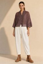 Mao Tencel Shirt in Burgundy – Μπλούζα με Mao Γιακά & Ιδιαίτερα Κουμπιά Χαρακτηριστικά Προϊόντος Σύνθεση: 95% Tencel – 5% lycra Ύφασμα: Λεπτό, σταθερό Tencel Υφή: Απαλή και λεία, με ανάλαφρη αίσθηση Γραμμή: Άνετη – relaxed fit Μέγεθος: One Size – καλύπτει από Small έως Extra Large Μανίκια: Φαρδιά, τρουακάρ  Οδηγίες Φροντίδας Για τη διατήρηση της υφής, των χρωμάτων και των ιδιαίτερων διακοσμητικών λεπτομερειών του Tencel, προτείνεται ήπια φροντίδα. 30°C – Πλύσιμο σε κρύο νερό, σε πρόγραμμα για ευαίσθητα, εφόσον το επιτρέπει η ετικέτα. Ήπιο στύψιμο ή χωρίς στύψιμο, για την προστασία του υφάσματος και των διακοσμητικών κορδονιών. ⊠ Όχι στεγνωτήριο. □ Φυσικό στέγνωμα στη σκιά, μακριά από άμεση ηλιακή ακτινοβολία. Πλύσιμο από την ανάποδη πλευρά, κατά προτίμηση μέσα σε ειδική θήκη προστασίας. Αποφύγετε την έντονη τριβή και το τράβηγμα των διακοσμητικών κόμπων.