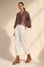 Mao Tencel Shirt in Burgundy – Μπλούζα με Mao Γιακά & Ιδιαίτερα Κουμπιά Χαρακτηριστικά Προϊόντος Σύνθεση: 95% Tencel – 5% lycra Ύφασμα: Λεπτό, σταθερό Tencel Υφή: Απαλή και λεία, με ανάλαφρη αίσθηση Γραμμή: Άνετη – relaxed fit Μέγεθος: One Size – καλύπτει από Small έως Extra Large Μανίκια: Φαρδιά, τρουακάρ  Οδηγίες Φροντίδας Για τη διατήρηση της υφής, των χρωμάτων και των ιδιαίτερων διακοσμητικών λεπτομερειών του Tencel, προτείνεται ήπια φροντίδα. 30°C – Πλύσιμο σε κρύο νερό, σε πρόγραμμα για ευαίσθητα, εφόσον το επιτρέπει η ετικέτα. Ήπιο στύψιμο ή χωρίς στύψιμο, για την προστασία του υφάσματος και των διακοσμητικών κορδονιών. ⊠ Όχι στεγνωτήριο. □ Φυσικό στέγνωμα στη σκιά, μακριά από άμεση ηλιακή ακτινοβολία. Πλύσιμο από την ανάποδη πλευρά, κατά προτίμηση μέσα σε ειδική θήκη προστασίας. Αποφύγετε την έντονη τριβή και το τράβηγμα των διακοσμητικών κόμπων.